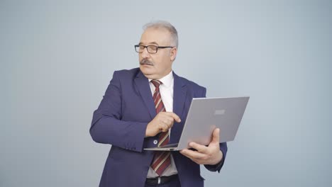 Businessman-looking-at-laptop-with-scared-expression.